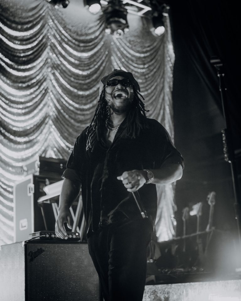 Leon Thomas live on stage, with a full band and a crowd of adoring fans